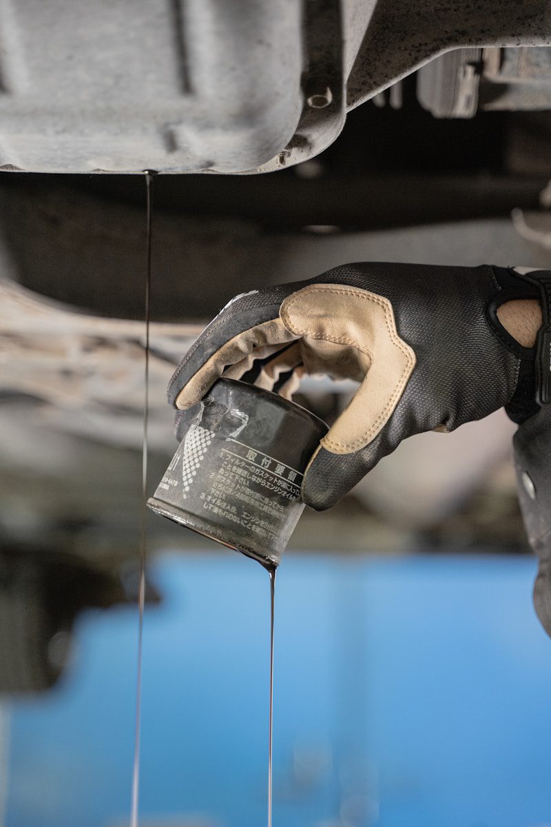 a mechanic is pouring oil from a car